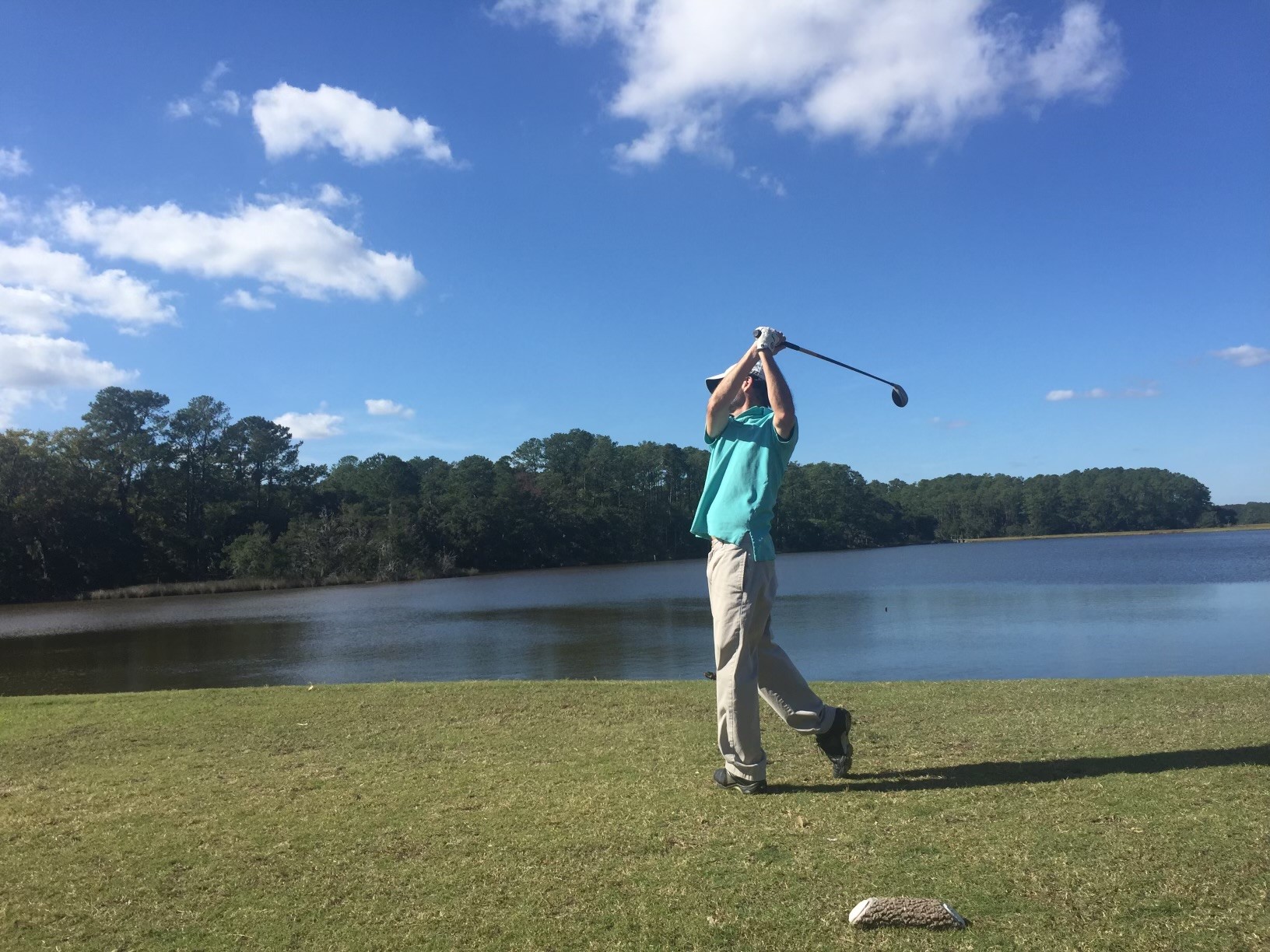 player teeing off with the lake in the background
